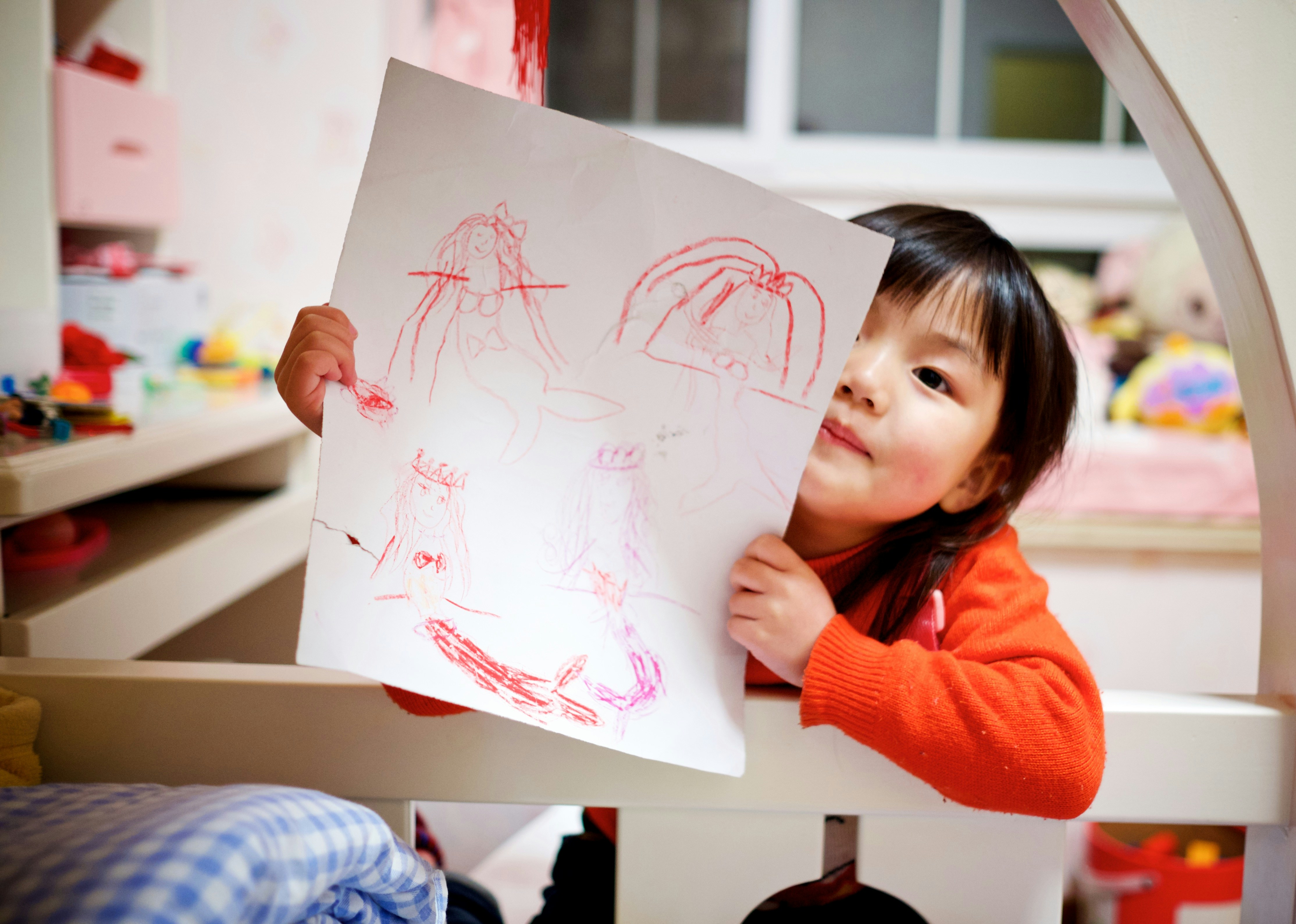 preschool girl holding drawing